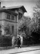 Abbe mit Strohhut am Gartentor seines Hauses um 1900.
