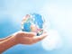 World environment day concept: Human hands holding earth global over blurred blue nature background. Elements of this image furnished by NASA