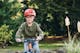 Хлопчик в окулярах та захисному шоломі катається на велосипеді в парку.